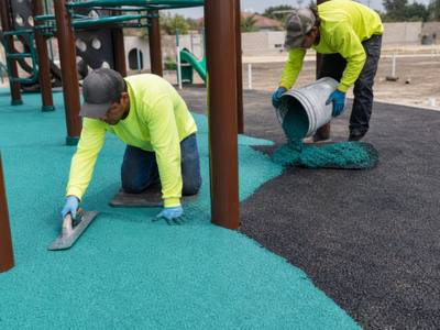 Crew installing rubber playground surfacing